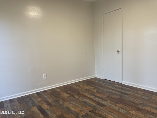 unfurnished room with dark wood finished floors and baseboards