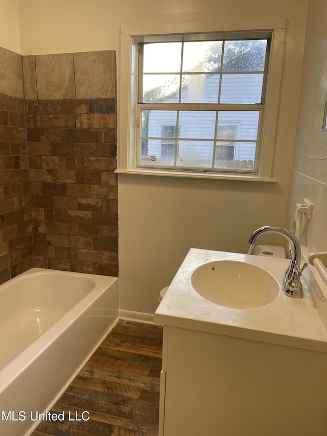 full bath with baseboards, wood finished floors, and vanity