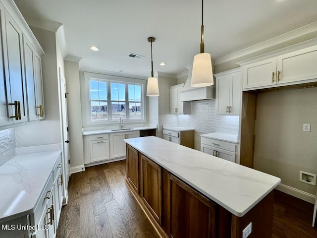 2892 Market Square Ave, Southaven, MS 38672 - kitchen featuring light stone countertops, a sink, dark wood-type flooring, crown molding, and backsplash
