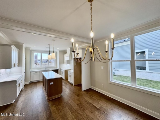 2892 Market Square Ave, Southaven, MS 38672 - kitchen featuring a sink, a notable chandelier, a kitchen island, baseboards, and ornamental molding