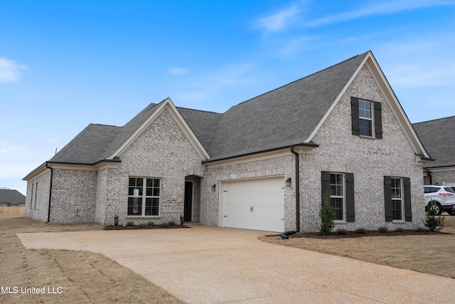 3786 Roland Dr, Southaven, MS 38672 - french country style house with concrete driveway, roof with shingles, brick siding, and an attached garage