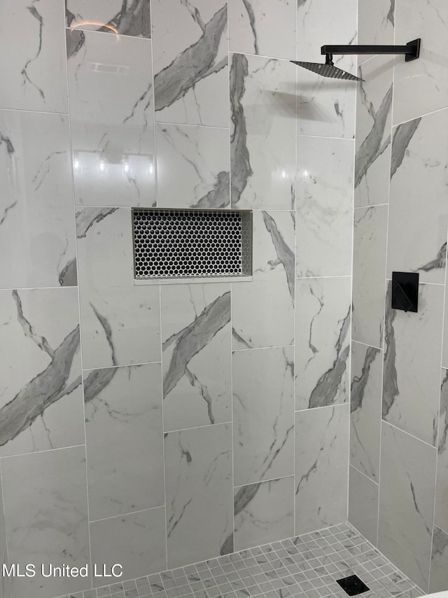 interior details featuring a tile shower