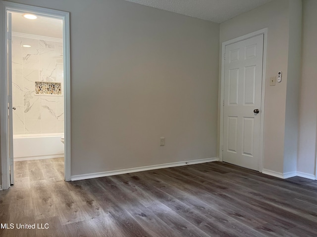 spare room featuring a textured ceiling and hardwood / wood-style flooring