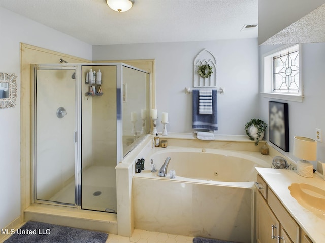 bathroom with a textured ceiling, a tub with jets, and a shower stall