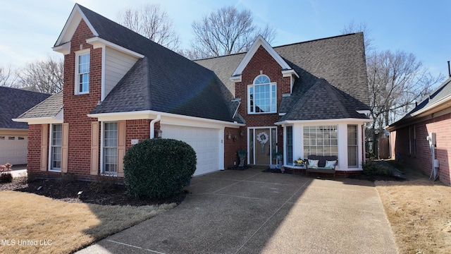 view of front of property featuring concrete driveway, brick siding, an attached garage, and roof with shingles