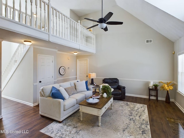 living area with high vaulted ceiling, wood finished floors, visible vents, and stairs