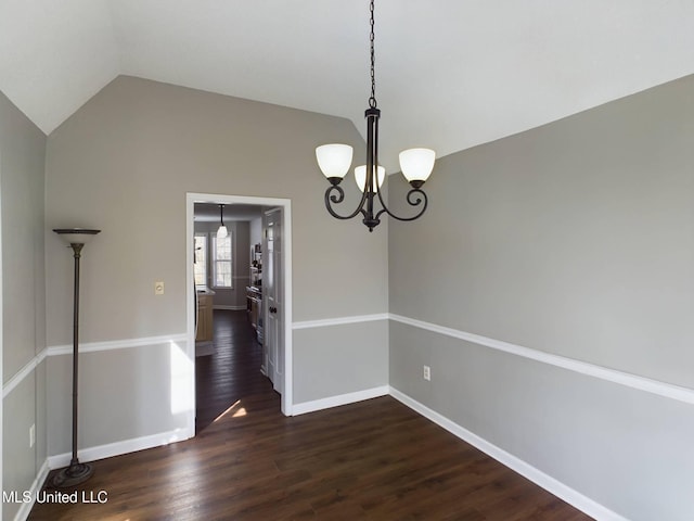 unfurnished dining area featuring dark wood-style floors, vaulted ceiling, an inviting chandelier, and baseboards