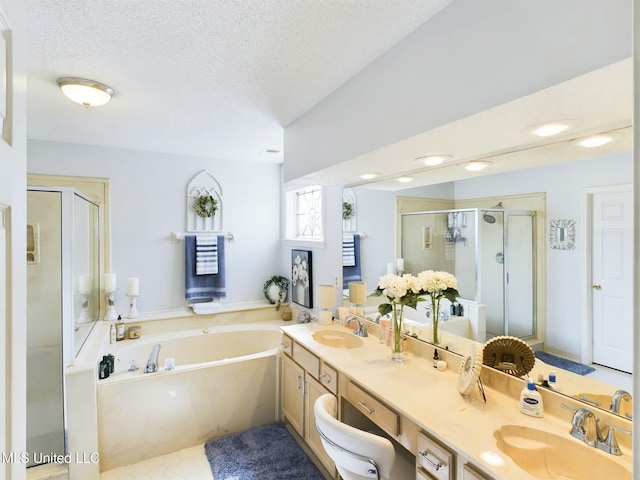 full bath featuring a bath, a shower stall, a textured ceiling, and a sink