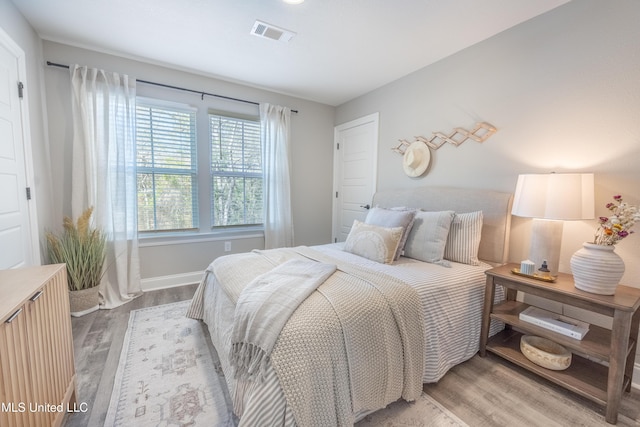 bedroom with visible vents, baseboards, and light wood-style floors