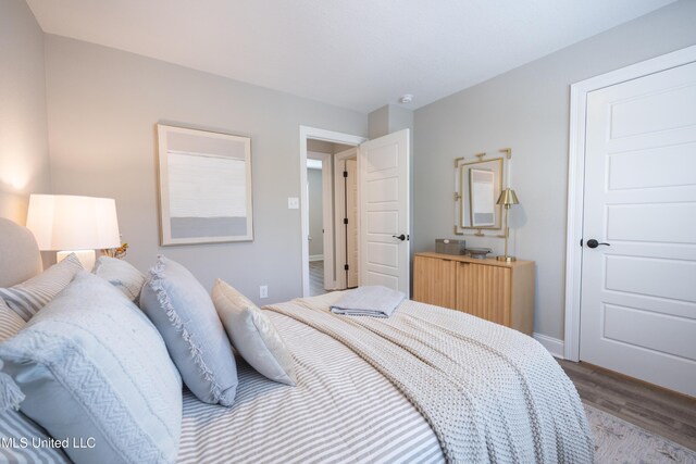 bedroom with wood finished floors and baseboards