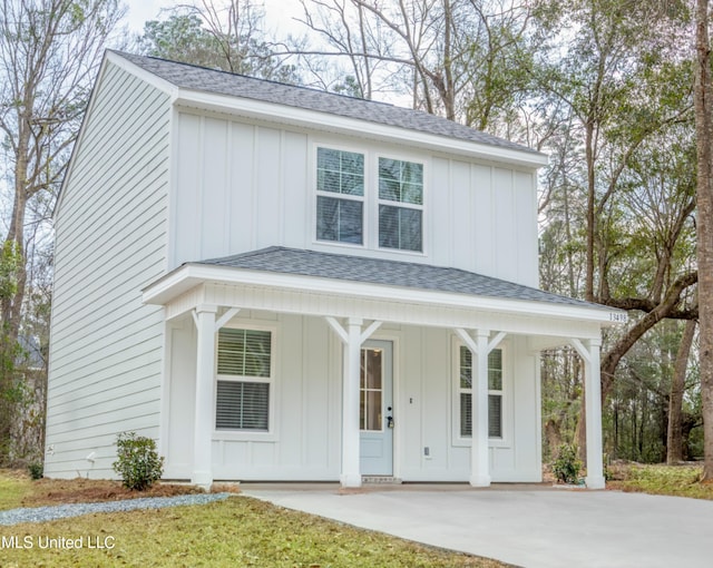 view of front facade with board and batten siding and a shingled roof
