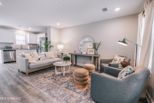 living area featuring recessed lighting, visible vents, and wood finished floors
