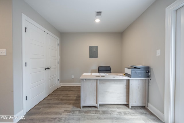 unfurnished office with electric panel, visible vents, recessed lighting, wood finished floors, and baseboards