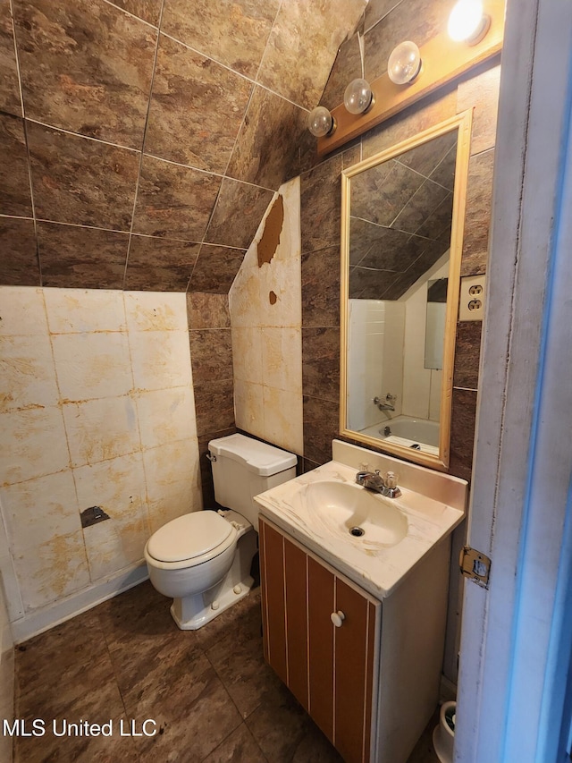 bathroom featuring vanity, toilet, and vaulted ceiling