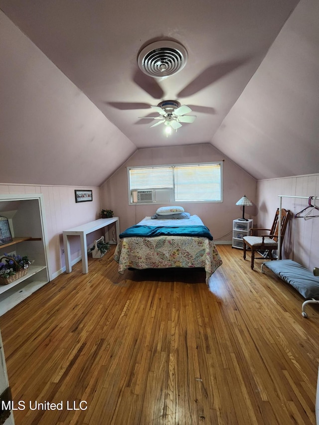 bedroom featuring cooling unit, ceiling fan, vaulted ceiling, and light hardwood / wood-style flooring