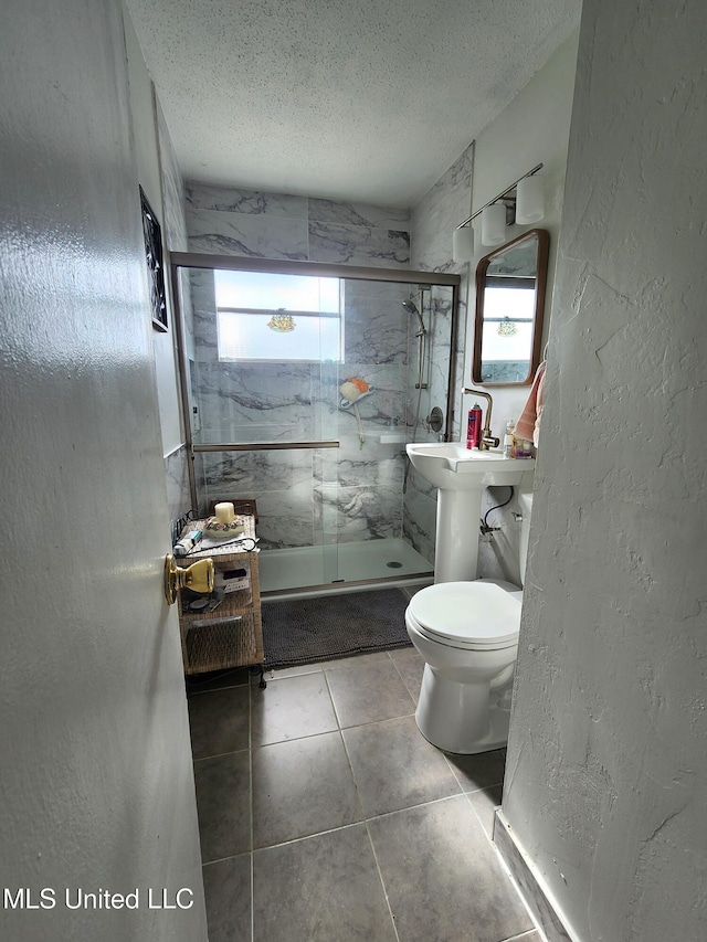 bathroom featuring shower / bath combination with glass door, toilet, and a textured ceiling