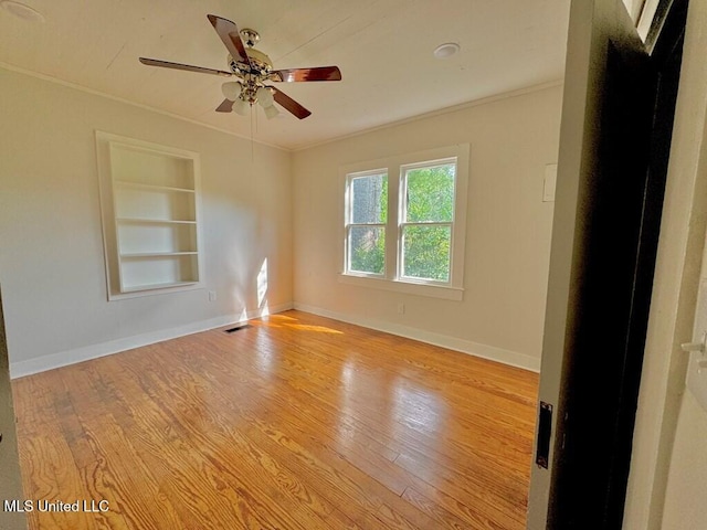 319 S 4th St, Mccomb, MS 39648 - empty room featuring built in features, wood finished floors, baseboards, a ceiling fan, and crown molding