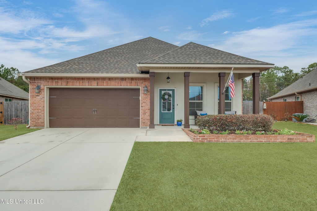 view of front of property featuring a garage, covered porch, and a front lawn