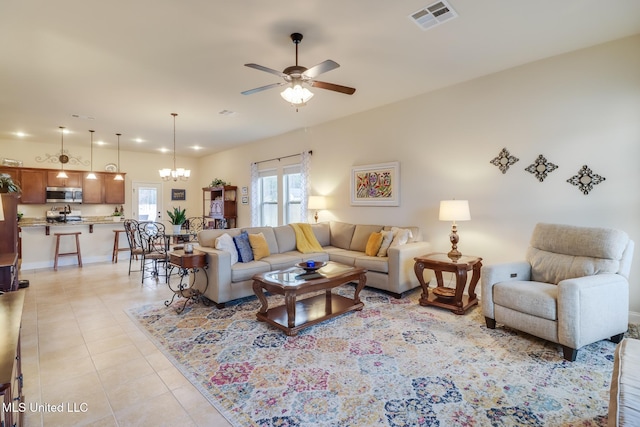 tiled living room with ceiling fan with notable chandelier