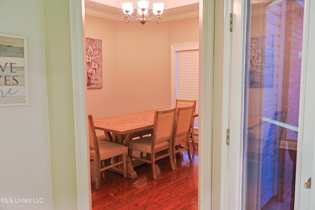 dining room with crown molding, hardwood / wood-style floors, and an inviting chandelier