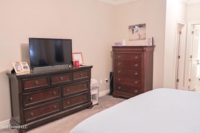 bedroom featuring crown molding and light carpet