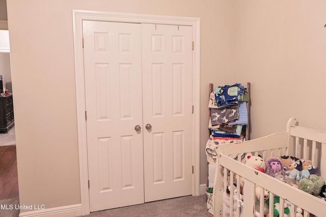 bedroom featuring a nursery area, carpet, and a closet