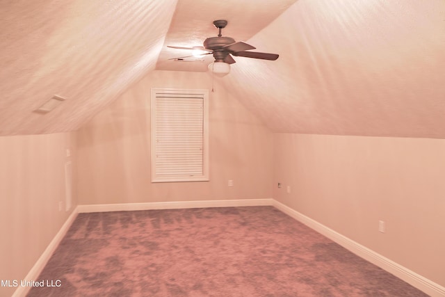 bonus room featuring lofted ceiling, a textured ceiling, ceiling fan, and carpet