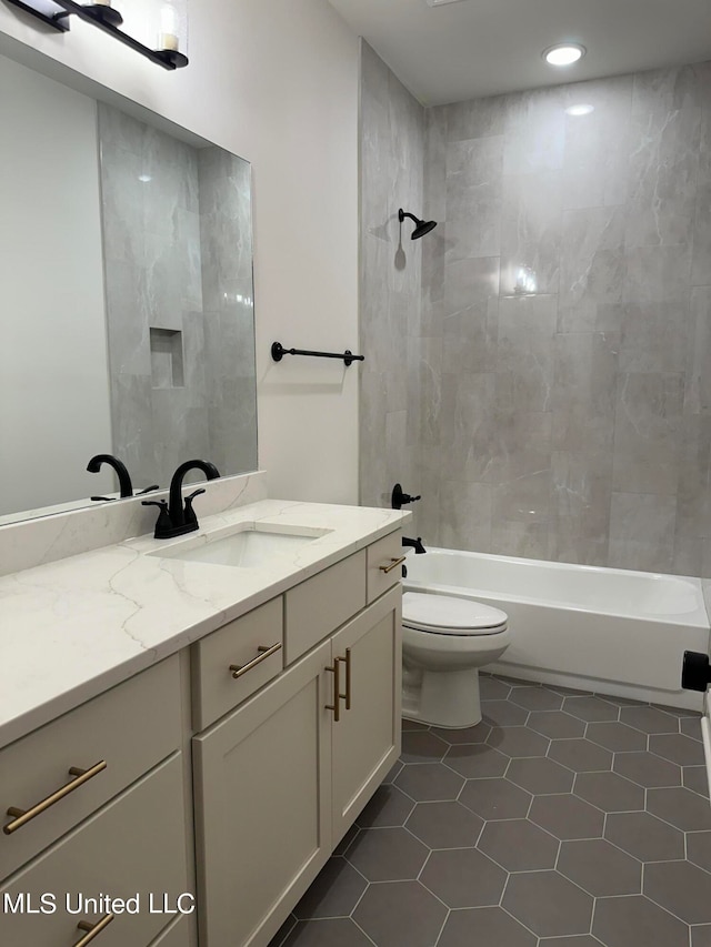 full bathroom with tile patterned flooring, vanity, tiled shower / bath combo, and toilet