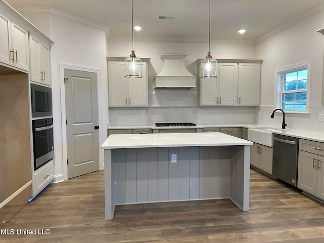 kitchen with gray cabinetry, dark wood-type flooring, premium range hood, decorative light fixtures, and appliances with stainless steel finishes