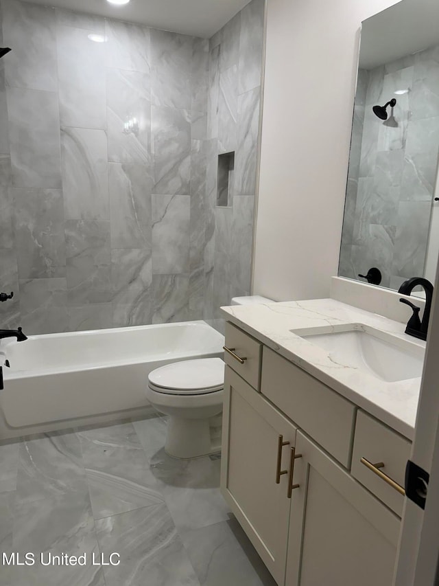 full bathroom featuring tiled shower / bath, vanity, and toilet