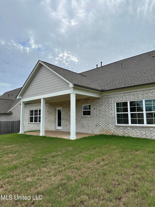 rear view of property featuring a patio area and a lawn