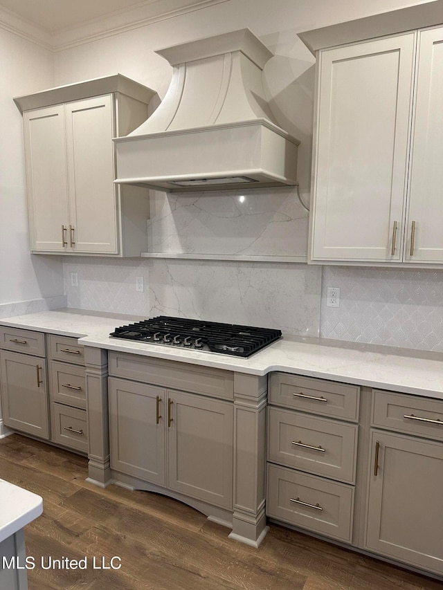 kitchen featuring gray cabinetry, backsplash, premium range hood, dark wood-type flooring, and gas cooktop