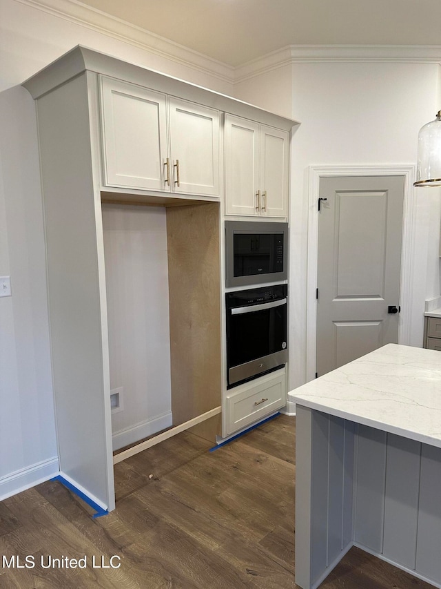 kitchen with built in microwave, light stone counters, dark hardwood / wood-style flooring, oven, and ornamental molding