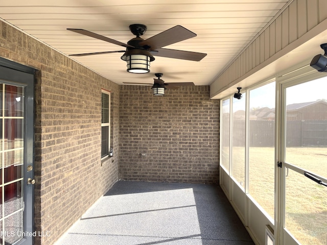 unfurnished sunroom with ceiling fan