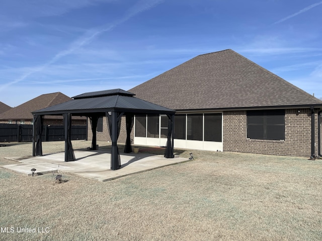 back of property with a gazebo, a yard, and a patio area