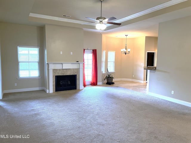 unfurnished living room with crown molding, a tile fireplace, a raised ceiling, and carpet flooring