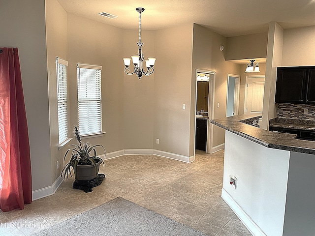 kitchen with tasteful backsplash, decorative light fixtures, and an inviting chandelier