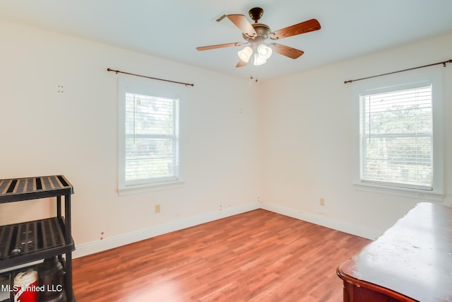 603 James Ave, Wiggins, MS 39577 - unfurnished bedroom with wood finished floors, multiple windows, and a ceiling fan