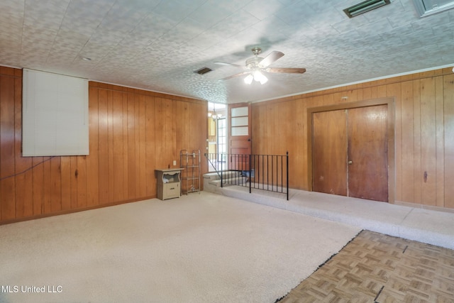 603 James Ave, Wiggins, MS 39577 - unfurnished bedroom featuring wood walls, ceiling fan, and carpet floors