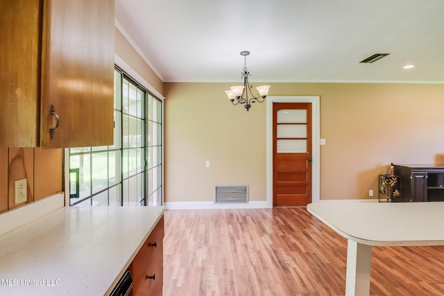 603 James Ave, Wiggins, MS 39577 - dining space featuring light wood-type flooring, crown molding, and a chandelier