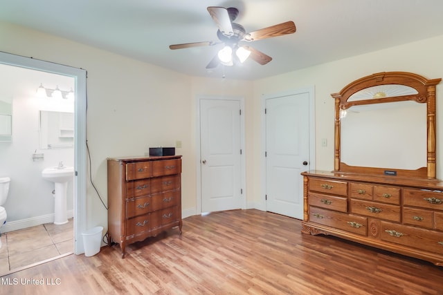 603 James Ave, Wiggins, MS 39577 - bedroom with light wood finished floors, ensuite bathroom, and a ceiling fan
