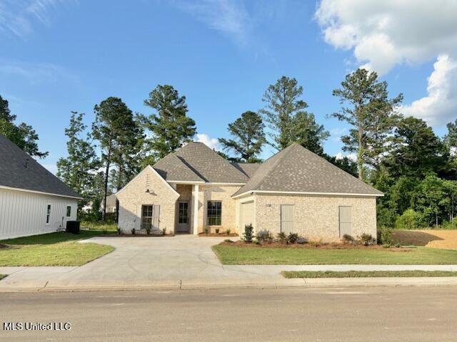 108 Hutto Ln, Madison, MS 39110 - french country home with concrete driveway, a garage, and a front lawn