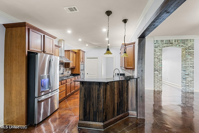 kitchen with wall chimney range hood, sink, stainless steel appliances, decorative light fixtures, and crown molding