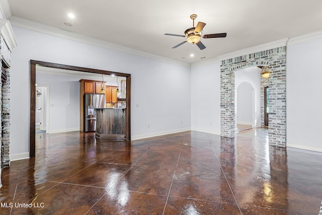 unfurnished living room featuring ceiling fan, arched walkways, ornamental molding, and baseboards