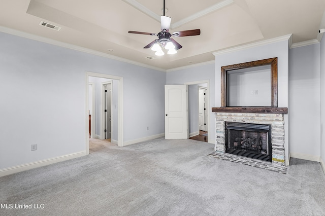 unfurnished living room with a fireplace, a raised ceiling, light carpet, ceiling fan, and ornamental molding