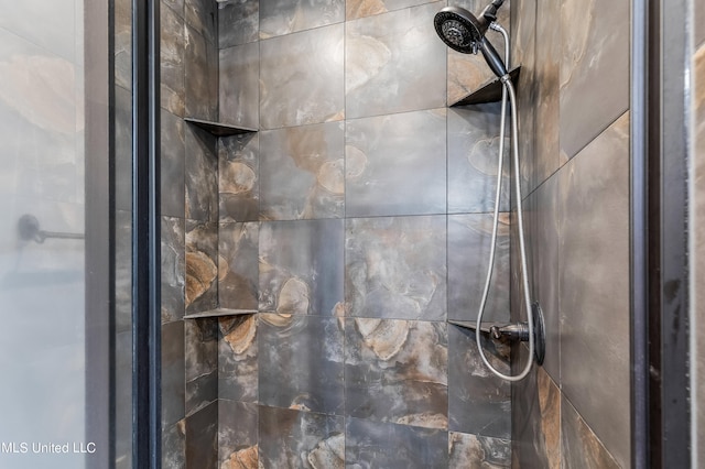 interior details featuring tiled shower