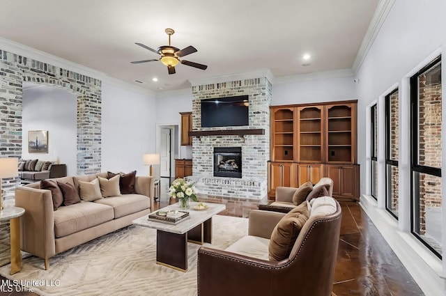 living room featuring ceiling fan, crown molding, and a fireplace