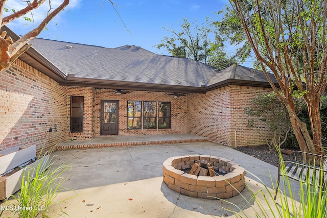 rear view of house featuring a fire pit, brick siding, a shingled roof, and ceiling fan