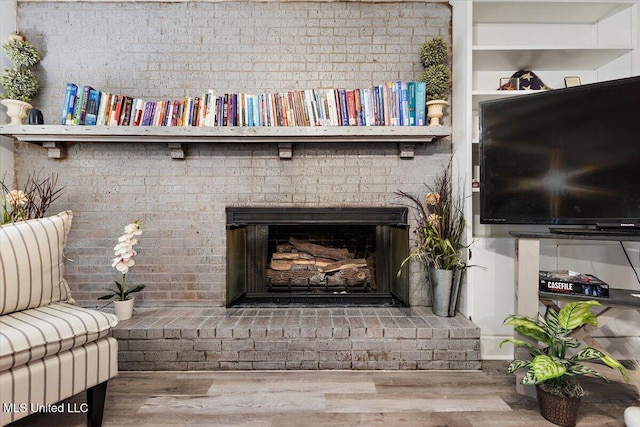 details with a brick fireplace and wood-type flooring