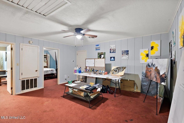 carpeted home office featuring crown molding, a textured ceiling, and ceiling fan